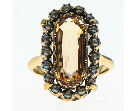 Imperial topaz ring. Central stone (15mm x 6mm) is surrounded by a halo of seed pearls and set in yellow metal. Size J 1/2. G