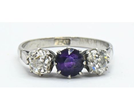 Diamond and amethyst three stone ring. Two old cut diamonds (approx 4mm dia.) flanking a dark amethyst claw set in platinum. 