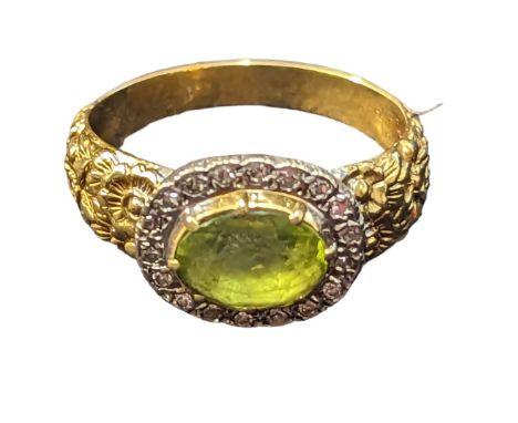 Peridot and diamond cluster ring, stone set in white metal and mounted on 18ct gold with floral relief to shoulders. Size P, 