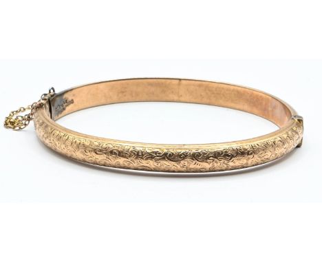Late Victorian 9ct gold hinged bangle, engraved scroll decoration to the front, hallmarked Chester 1900, inner width 60mm, 8.