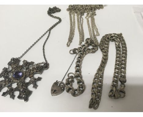 A silver gate bracelet and silver chain and other chain .