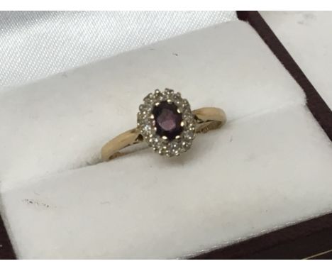 An 18carat gold ring set with a central ruby flanked by small diamonds. Weight 2.3g ring size J.