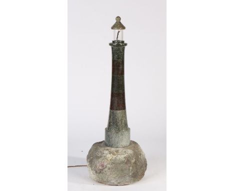 A 20th century Cornish serpentine marble lighthouse lamp, on rock base, 84cm high.