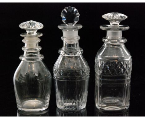 A group of three late Georgian spirit decanters comprising a plain Prussian form example, a similar decanter with cut decorat