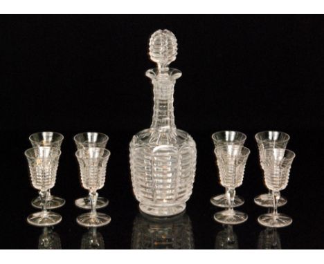 An early 20th Century decanter and eight matched glasses, possibly Webb Corbett, with panels of horizontal mitre cuts all wit