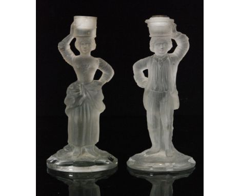 A pair of late 19th Century Baccarat pressed glass candlestick, the columns in the form of a lady and gentleman in a frosted 