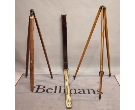 A similar pair of early 20th century hardwood surveyor's tripods 157cm tall, and a large measuring stick, 122cm tall. 