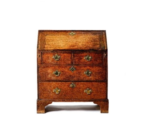 An oak bureau, mid 18th century, the hinged fall enclosing a fitted interior, with two short and two long drawers below, on b