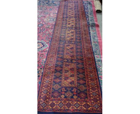 An Indian runner of Turkman design, the black field with six rectangular sections, supported by stylised diamonds, 330cm x 76
