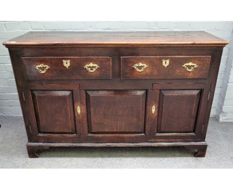 An oak low dresser, 18th century, of panelled construction, with two drawers and cupboard below, on bracket feet, 145cm wide 