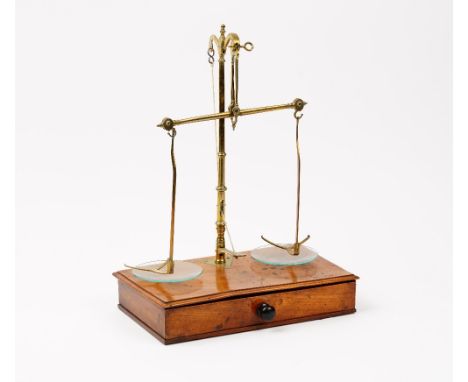 A pharmacist’s Victorian walnut and brass set of beam scales, the drawer fitted with the weights, 27cm wide.