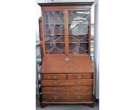 A George III mahogany bureau bookcase, the pair of glazed doors over fitted interior, with two short and three long graduated