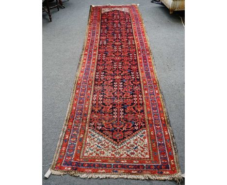 A Hamadan runner, Persian, the dark indigo field with an allover herate design, ivory ends; three borders, 408cm x 105cm.