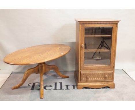 'ERCOL' ; A modern oval coffee table on four downswept supports, 122cm wide x 51cm high, and a matching 'ERCOL' side cabinet,