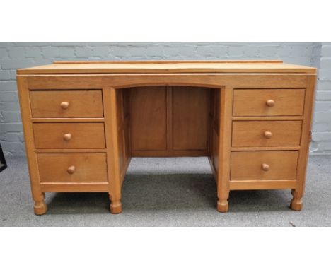 Robert Mouseman Thompson; A 20th century blonde oak dressing table with six drawers about the knee, on octagonal supports, 13