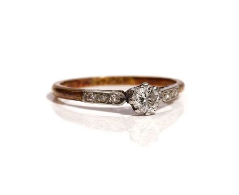 A gold and platinum ring, claw set with the principal circular cut diamond at the centre, between diamond set three stone sho