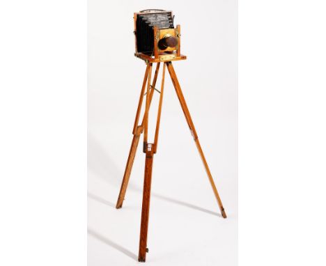 A mahogany cased plate camera, early 20th century, with a three section oak stand. 