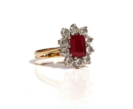 A gold, ruby and diamond set cluster ring, claw set with the cut cornered rectangular ruby to the centre, in a surround of te