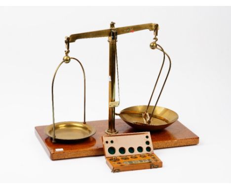 A set of Maw Class B brass beam scales, on a wooden base, 50.5cm wide, and a cased set of weights labelled ‘F E Becker &amp; 