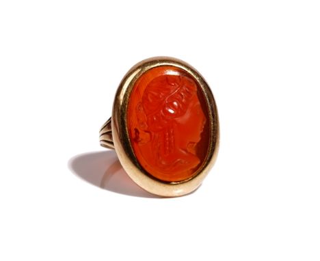 A gold and oval cornelian cameo ring, carved as the portrait of a classical lady, between ridged shoulders, ring size L, gros
