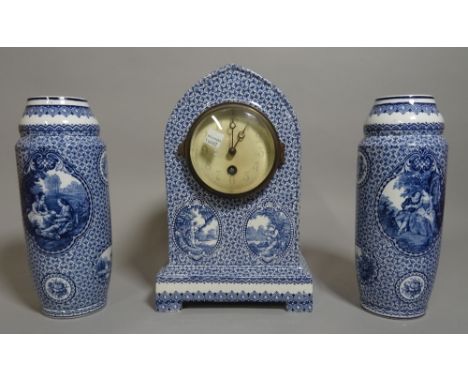A 20th century blue and white ceramic clock garniture with a pair of cylindrical vases 27cm high (3). 