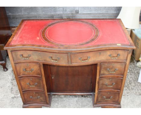A mahogany and banded serpentine front double pedestal desk with red leather tooled lined top, fitted eight drawers and centr