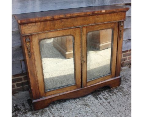 A late Victorian walnut and banded credenza/pier cabinet enclosed two arch top mirror panelled doors, on bracket feet, 48" wi