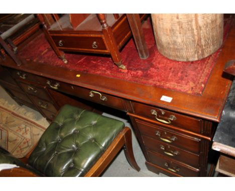 An Edwardian pedestal desk with red tooled leather lined top, fitted nine drawers, on bracket feet, 54" wide x 28" deep x 31"