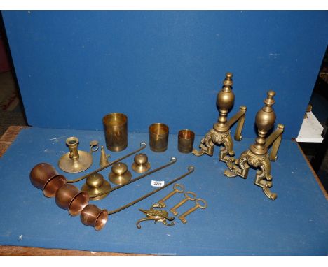 A pair of brass fire dogs, brass chamber stick, three copper measures, etc.