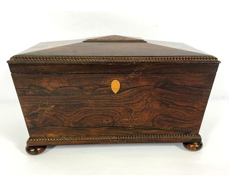 A George IV rosewood sarcophagus tea caddy, circa 1825, with beaded edges, the interior fitted with two canisters and a glass