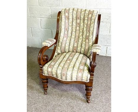 A Victorian mahogany easy chair, circa 1870, with scrolled over and button upholstered back and seat and padded and scrolled 