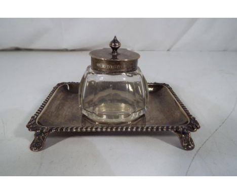 An Edward VII silver hallmarked inkwell stand with gadroon edge raised on four supports with glass and silver Birmingham assa