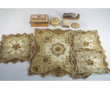 A good lot comprising four enamel boxes, a silver backed brush and four beadwork mats  Est £20 - £30