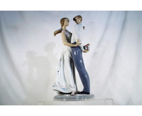 Lladro - A Lladro ceramic figural group # 6746 ' Love's Little Surprises' depicting a courting couple, stamped and impressed 
