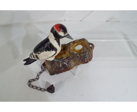 A cast iron door knocker in the form of a woodpecker Est £20 - £30