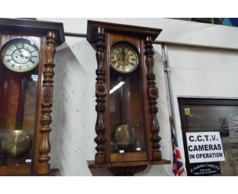 A large twin weight driven Vienna style wall clock, the walnut case having turned and carved decoration, two-piece celuloid d