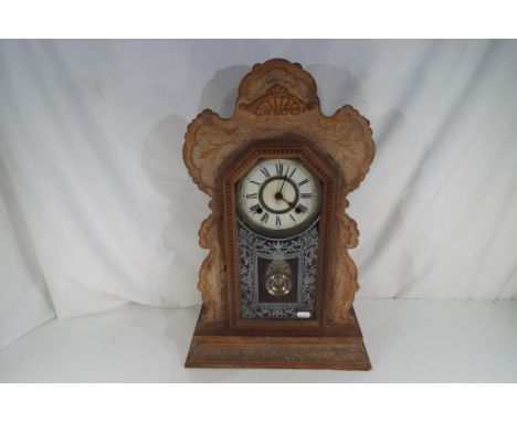 A 19th century American Ansonia eight-day shelf clock with scroll carved oak case, pendulum and key, 57 cm (high)