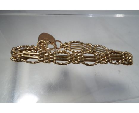 A lady's 9 carat gold gate bracelet with a 9 carat gold safety chain and padlock, approximate weight 20.05 g Est £150 - £200.