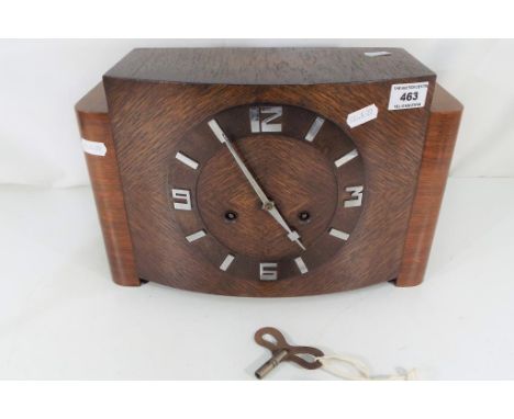 An Art Deco oak cased mantel clock having Arabic numerals to the chapter ring, with key and pendulum