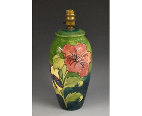 A Moorcroft Hibiscus ovoid lamp base, tube lined with large flowers in red, yellow and purple on a green ground, 27cm high, i