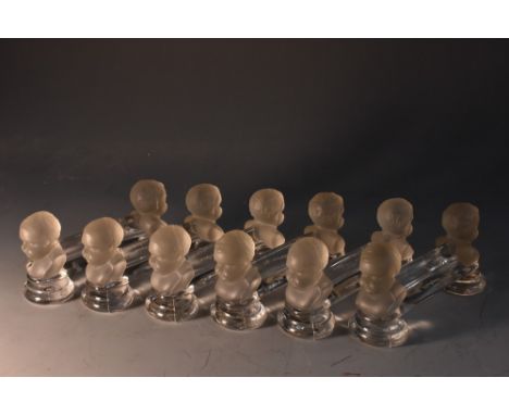 A set of six R Lalique Crystal de Houden Baby Face knife rests, 9cm wide, engraved