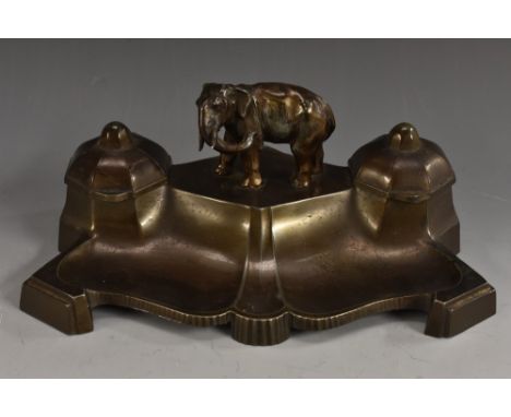 A continental spelter dark patinated inkstand, surmounted with a central naturalistically cast elephant, flanked by a pair in