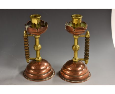 A pair of Arts and Crafts copper and brass candlesticks, after a design by Christopher Dresser, brass sconces, hexagonal pier