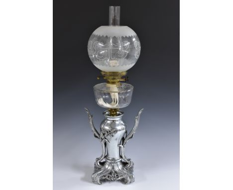 An Art Nouveau oil lamp, the cast metal base of vasular forn, sinuous leafy scroll handles, the base pierced with scrolls and