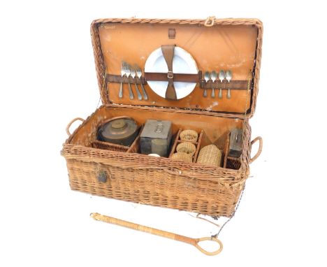 An early 20thC wicker picnic hamper, the hinged lid enclosing porcelain plates, cutlery, copper flask, glass beakers, etc, th