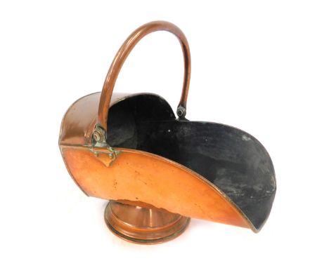 A Victorian copper coal scuttle, with helmet shaped and swing handle, 32cm high. 