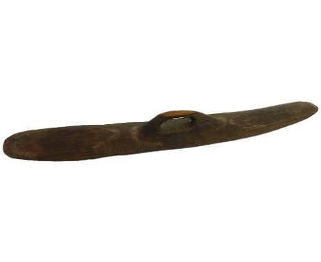 An aboriginal wooden shield, of rounded rectangular form, with handle and incised wave decoration, possibly from the Woomera,