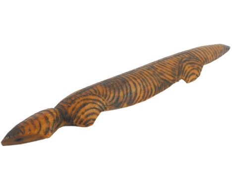 An aboriginal wooden poker work decorated animal, possibly a lizard, 32cm long. Provenance: acquired in 1963-4 while the vend