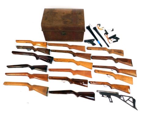 A tin trunk containing a collection of air rifle stocks. 