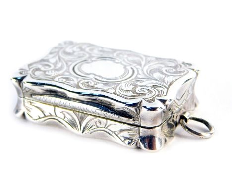 A Victorian silver vinaigrette box, of shaped rectangular form, scroll and leaf engraved with vacant cartouche, the hinged li